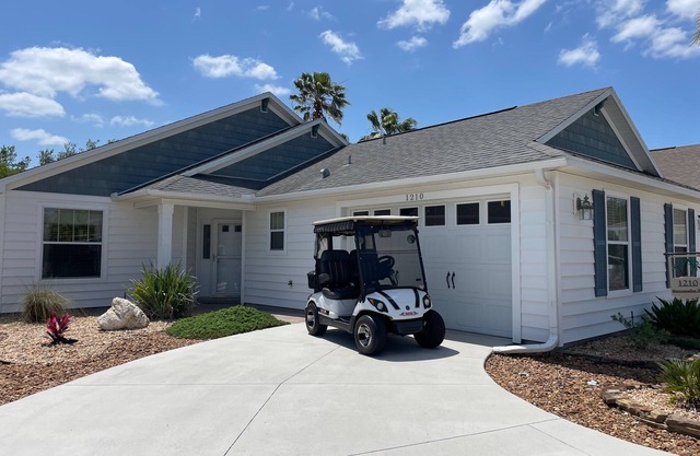 Sunlit open-concept retreat w/granite kitchen island, golf cart & dual lanai.