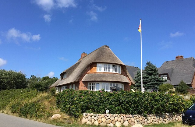 Maison de vacances au toit de chaume, vue directe sur la mer des Wadden, avec un grand jardin