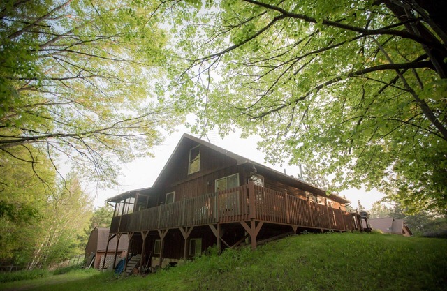 La maison de cèdre est uniquement située dans la forêt entourée de terrasses et de porches.
