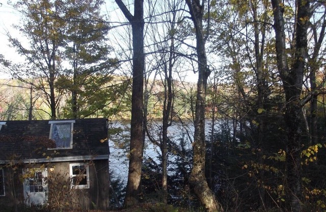Camp riverain rustique avec pont, bateaux avec huards, castors, faune, région du lac Sunapee