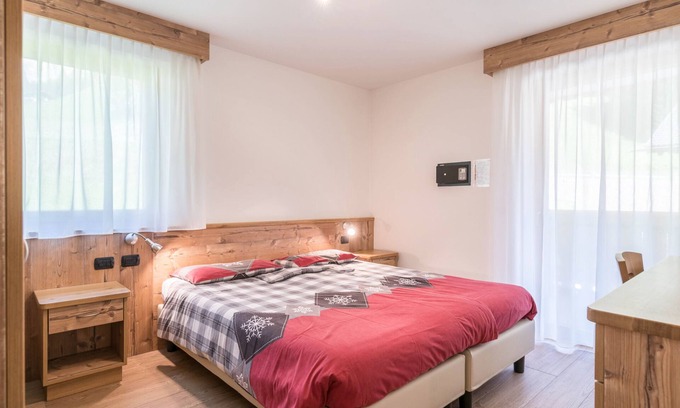 Canazei Appartement | Appartement Ciasa Rosa avec vue sur les montagnes, balcons et jardin partagé.