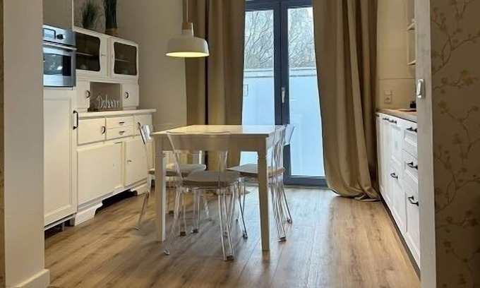 Hamburg-Barmbek Appartement | Bright apartment with a small, functional kitchen and a spacious dining area.