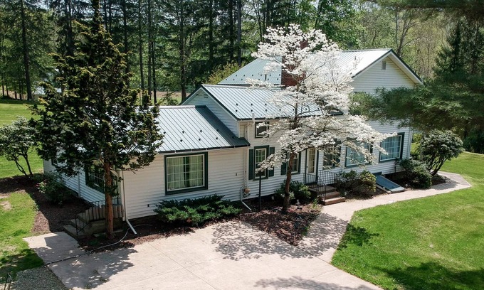 Hillsgrove Maison | Creek side house with fireplace and concrete driveway.
