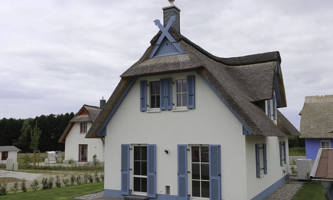 Stove Maison | Das Reetgedeckte Ferienhaus Seeschwalbe mit Blick auf die Historische Windmühle in Stove, ist ein Traumhaftes Urlaubsdomizil