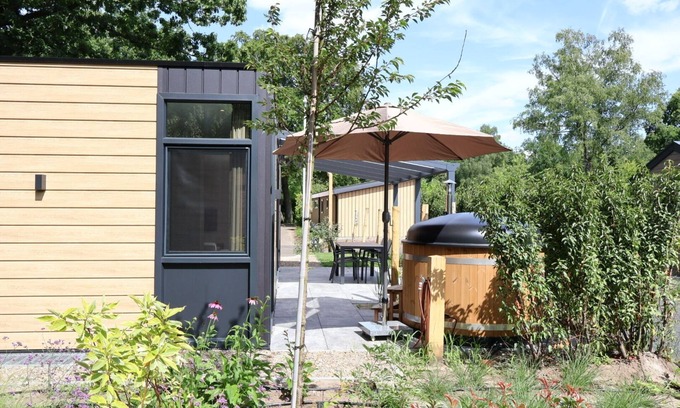 Lieren Maison | osendael: Stylish 4-person home with 2 bedrooms, each with en-suite bathrooms—one with a whirlpool and the other with a shower and sunshower—a hot tub, partially covered outdoor terrace, and modern kitchen. Enjoy luxury in the Veluwe!
