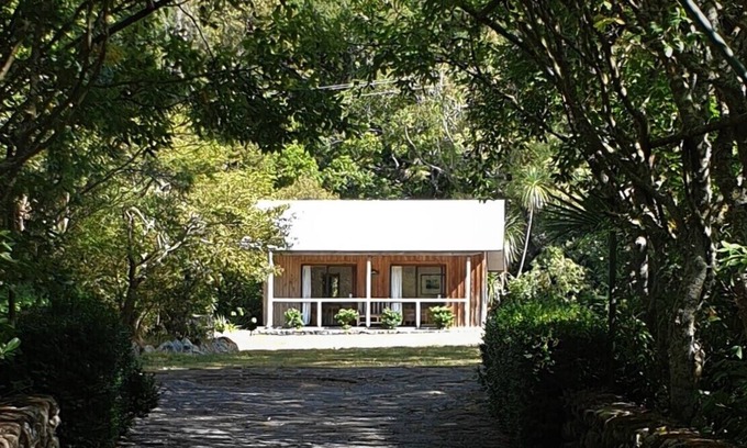 Western Lake Cabine | Cabane rustique et grand bloc de cuisine niché dans un jardin indigène.