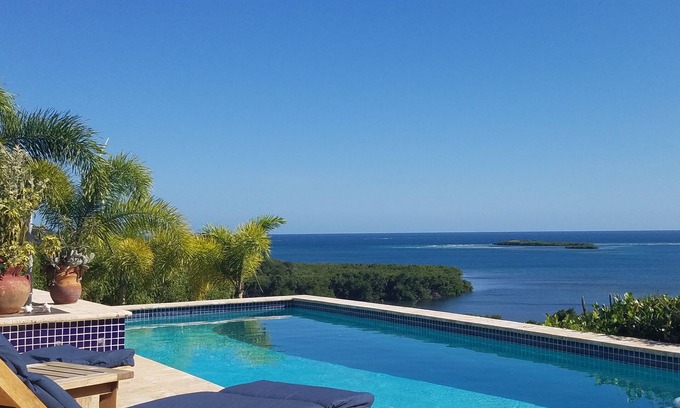 Fraile Maison | Rainbow Paradise est un 4BR / 3 moderne et magnifique sur le plan architectural. 5 BA maison sur un terrain de 5 acres surplombant les baies de Manglar et Pela. Très isolée et privée. A / C dans BR, ventilateurs de plafond, cuisine complète, piscine ex...
