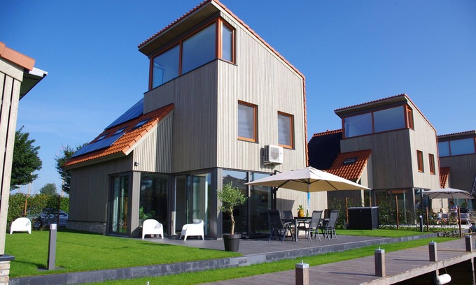 Heeg Maison | Vacation home on the water with boat, air conditioning, sauna, bike, SUP and BBQ